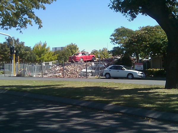 A car is left on top of the rubble once a house on Bealey Avenue, across from the cordoned off city under state of emergency